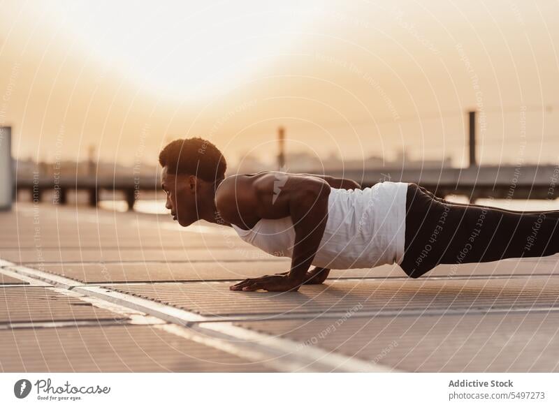 Strong black man doing plank exercise training workout determine athlete sport activity sea male endurance african american sportsman strong sportswear effort