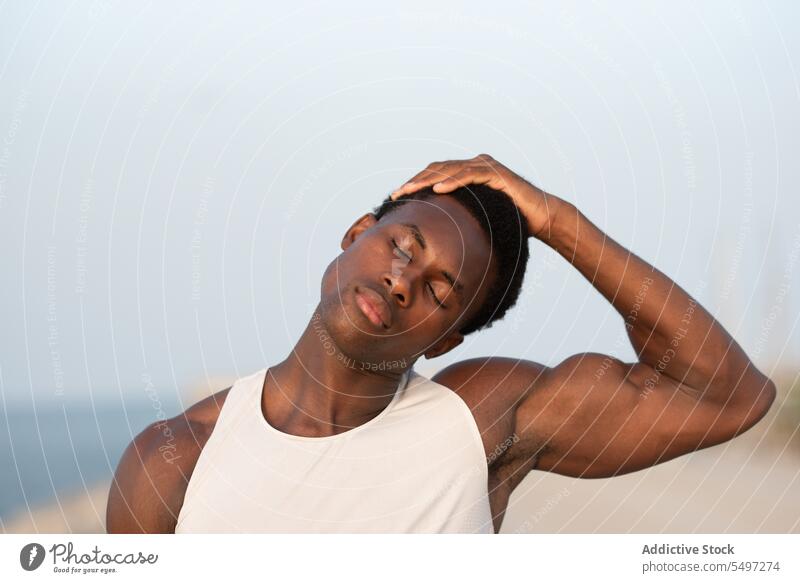 Black man touching head on embankment calm touch head serious sportsman portrait sportswear eyes closed tranquil pensive male thoughtful relax concentrate