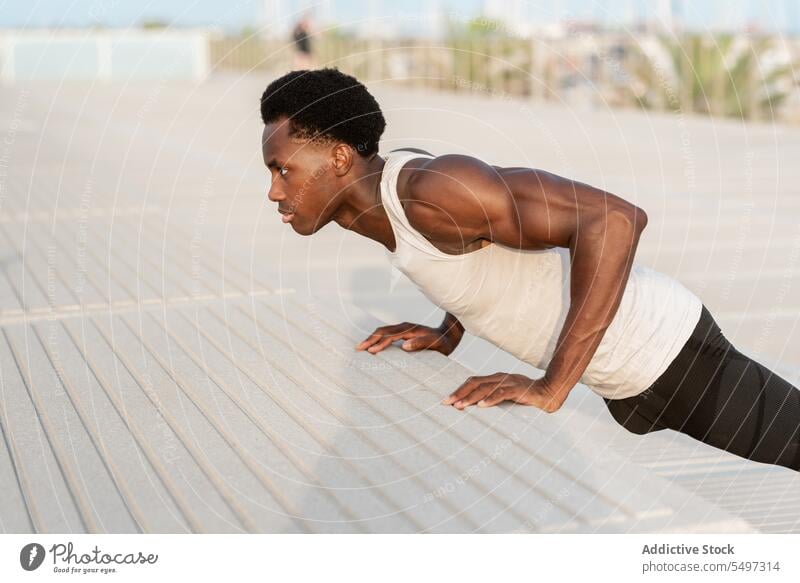 Black man doing push ups on embankment sea workout exercise sport portrait sportswear water training male african american healthy effort waterfront activity