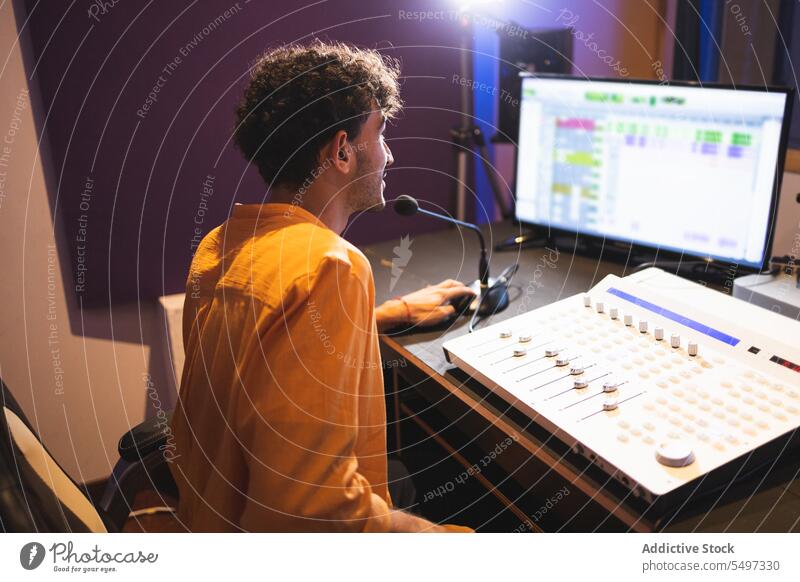 Man recording vocal in studio performer sing song audio engineer sound music black african american singer voice technician compose create produce industry