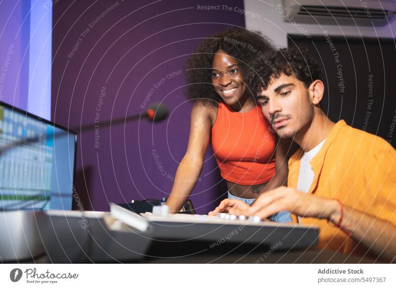 Man and black woman recording music in studio audio engineer singer song sound press button african american vocalist performer technician create produce adjust