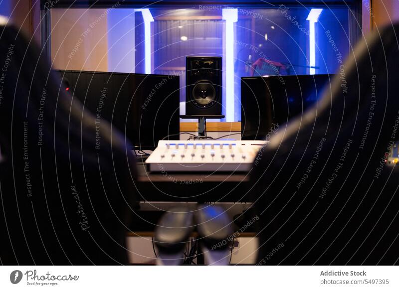 Professional blurred equipment for podcast on table and empty chair in studio lights computer interior monitor controller armchair illuminate device desk design
