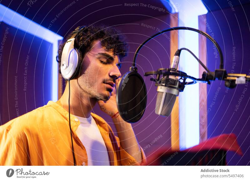 Man singing and recording song man singer music microphone studio take note male professional vocalist star musician perform entertain industry rehearsal album