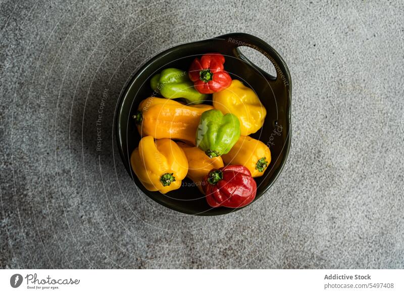 From above of different colored peppers bowl colorful vegetable food raw yellow orange fresh natural healthy gastronomy explosion ripe mix ingredient cook
