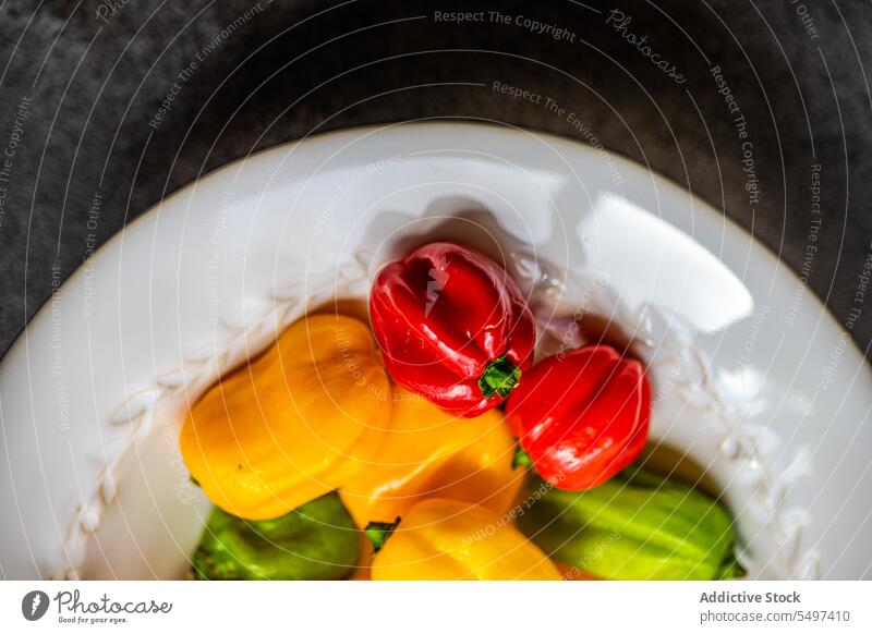 From above of different colored peppers plate dish colorful vegetable food raw yellow orange fresh natural healthy gastronomy explosion ripe mix ingredient cook