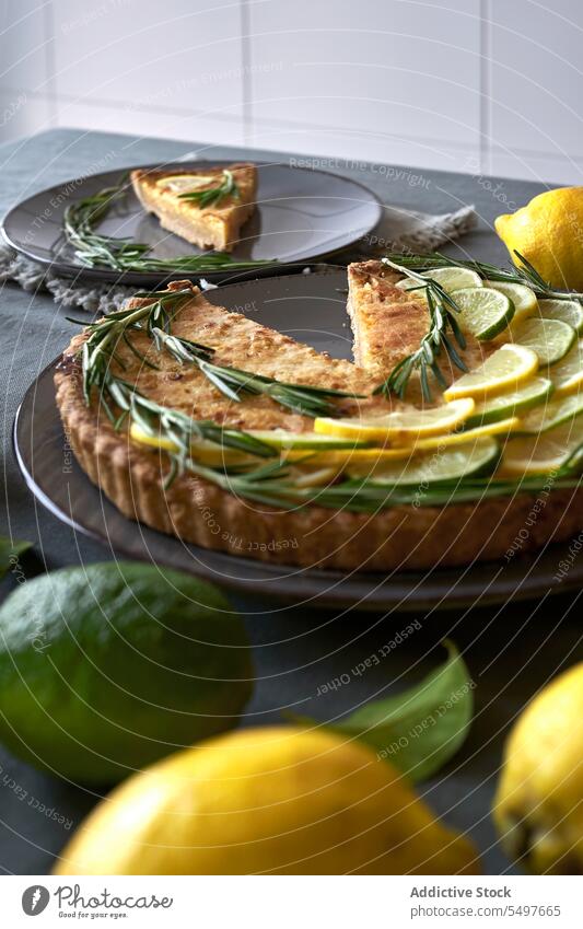 Lemon tart topped with lemon slices and rosemary leaves Lemon pie pastry homemade cuisine traditional treat cozy sweet culinary styling timeless pie