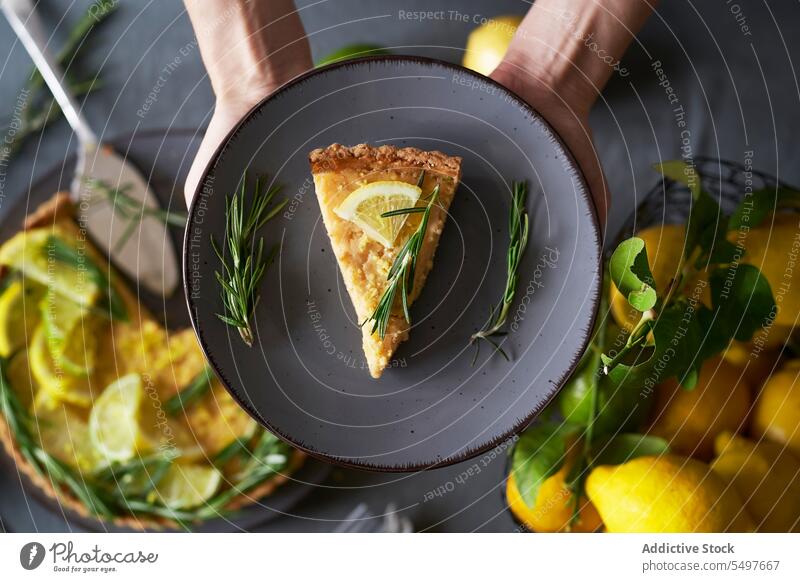 Body part of person holding a plate with a slice of lemon pie Lemon pie pastry homemade cuisine traditional recipe cozy sweet culinary styling timeless pie