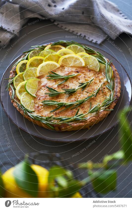 Lemon tart topped with lemon slices and rosemary leaves Lemon pie pastry homemade cuisine traditional recipe handcrafted treat autumn cozy sweet