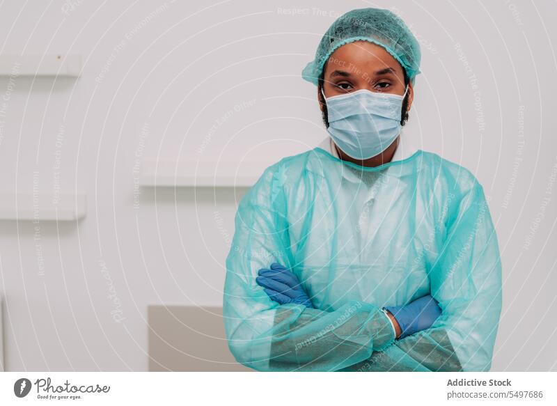 Ethnic male surgeon with folded arms looking at camera in hospital man doctor arms crossed professional specialist serious clinic medical portrait work young