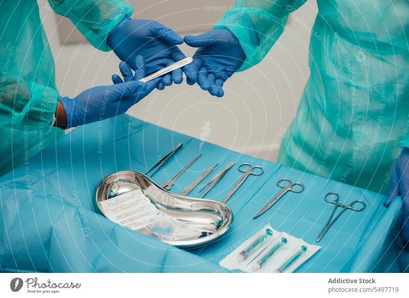 Assistant passing instrument to surgeon doctor assistant intern operate tool latex glove sterile surgery operation procedure operating room medical clinic