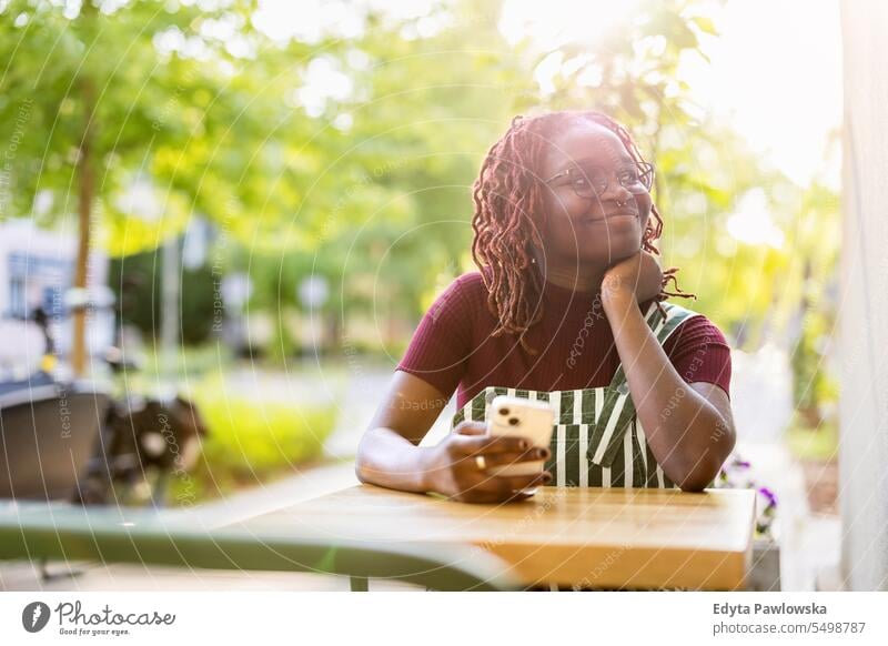Portrait of a black non-binary person sitting in an outdoor cafe real people positive confident adult young adult lifestyle authentic African american