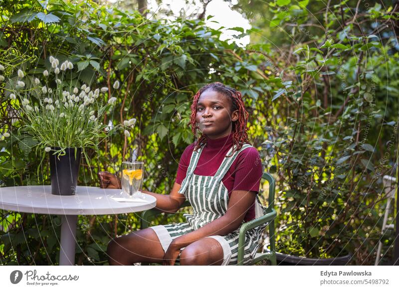 Portrait of a black non-binary person sitting in an outdoor cafe real people positive confident adult young adult lifestyle authentic African american
