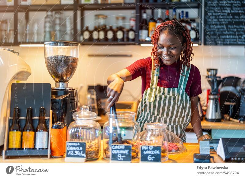 Portrait of a genderqueer barista making coffee at counter in coffee shop real people positive confident adult young adult lifestyle authentic person black