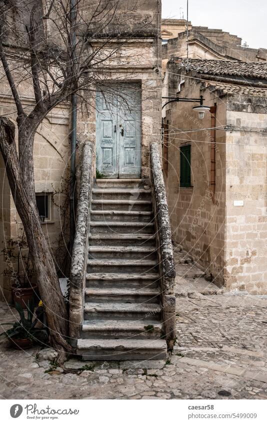 Abandoned staircase leading to a closed door in the typical Italian town of Matera, Southern Italy stairway scenic tree house old stairs stone blue antique