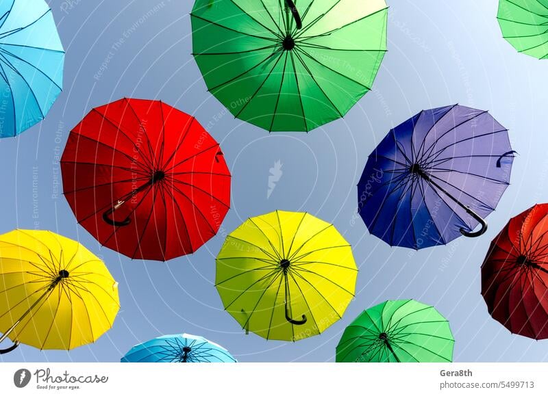 many colorful umbrellas fly and hover on the city street abstract art background blue bright concept creative day decor decoration design flying umbrella green