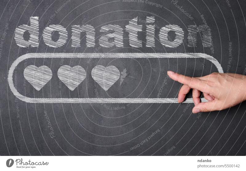 A hand pointing at a blackboard with the word donat written on it, below the word is a rectangular block with three hearts inside donation donate love donor