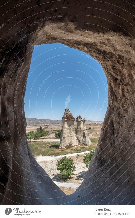 typical fairy chimney view from inside an dug out cave, geological formation of eroded rock, in the open air museum of Goreme, in Cappadocia, Turkey cappadocia