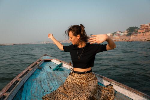 a young woman sitting on a wooden boat in Varanasi boating Water Watercraft Vacation & Travel Navigation Colour photo Exterior shot Tourism Trip Summer Tourist