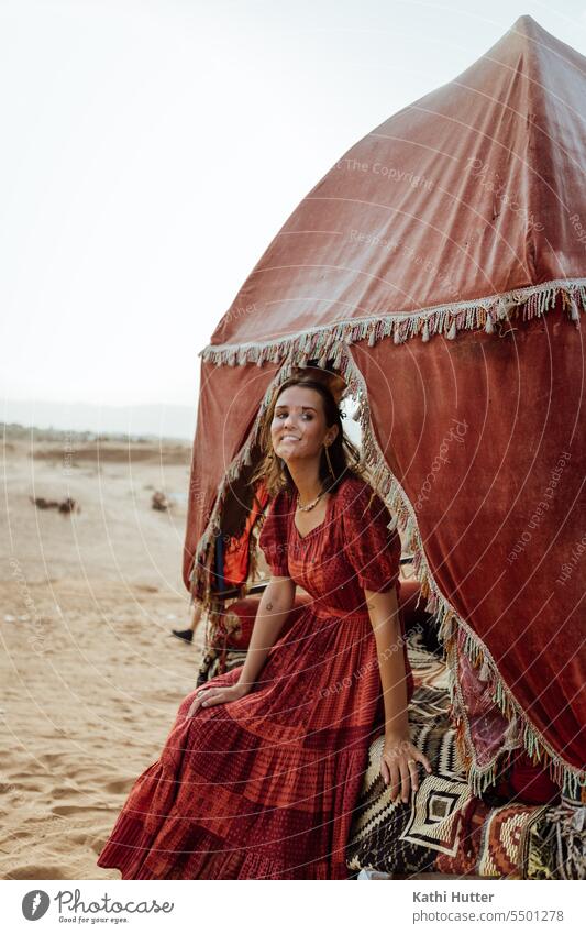 a young woman in a beautiful red dress, sitting in a trailer of a camel women female Woman Feminine Hair and hairstyles Face Eyes face portrait out Nature