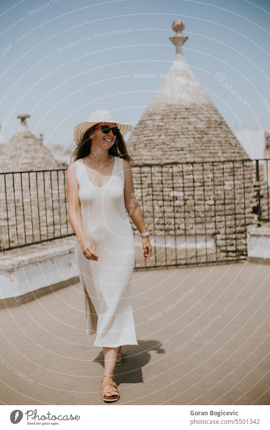 A young woman in a white dress and a hat during tourist visit in Alberobello, Italy architecture pretty people fashion lifestyle activity adult alberobello