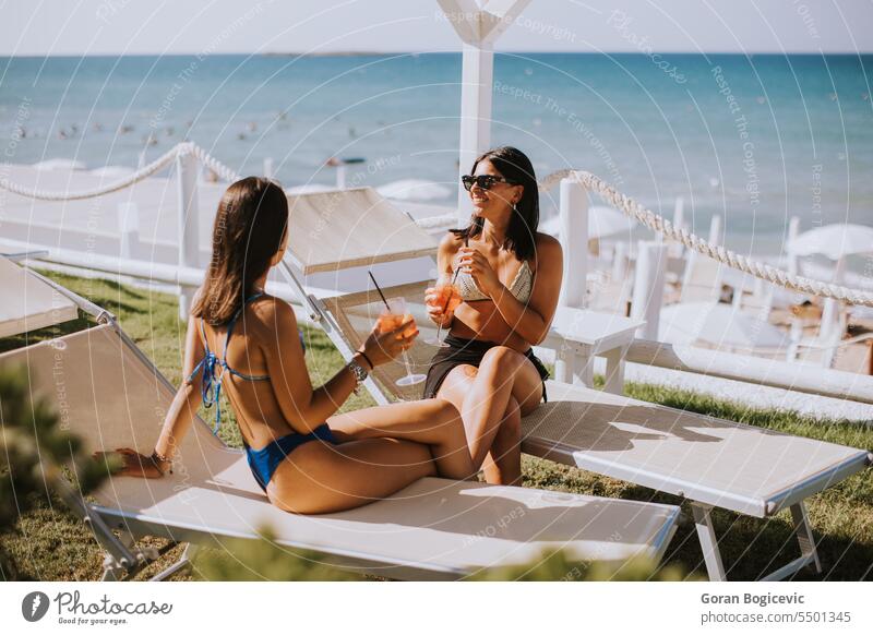 Smiling young women in bikini enjoying vacation on the beach happy sun sunglasses attractive people lifestyle leisure friendship together outdoors woman travel