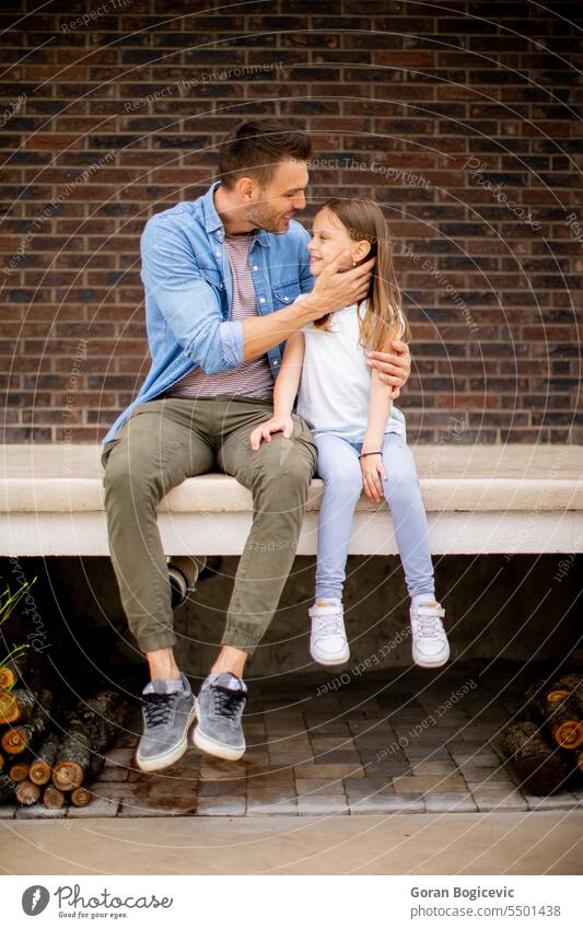 Father and his daughter have a good time in front of house door casual little adult bonding caucasian child childhood cute dad daddy enjoyment family father