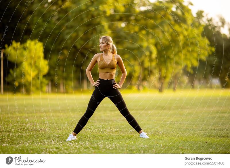 Pretty young woman stretching in the park body active activity adult athletic attractive beautiful beauty calm exercise female fit fitness grass green health