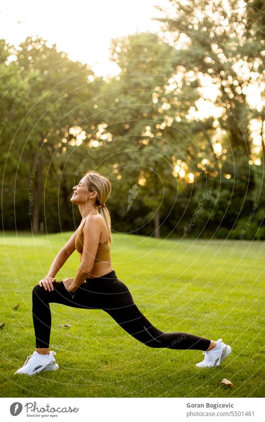 Pretty young woman stretching in the park body active activity adult athletic attractive beautiful beauty calm exercise female fit fitness grass green health