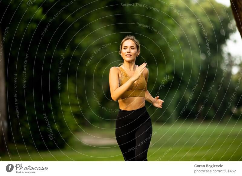 Pretty young woman running in the park people activity action active adult athletic attractive attractive woman beautiful cardio caucasian energy exercise