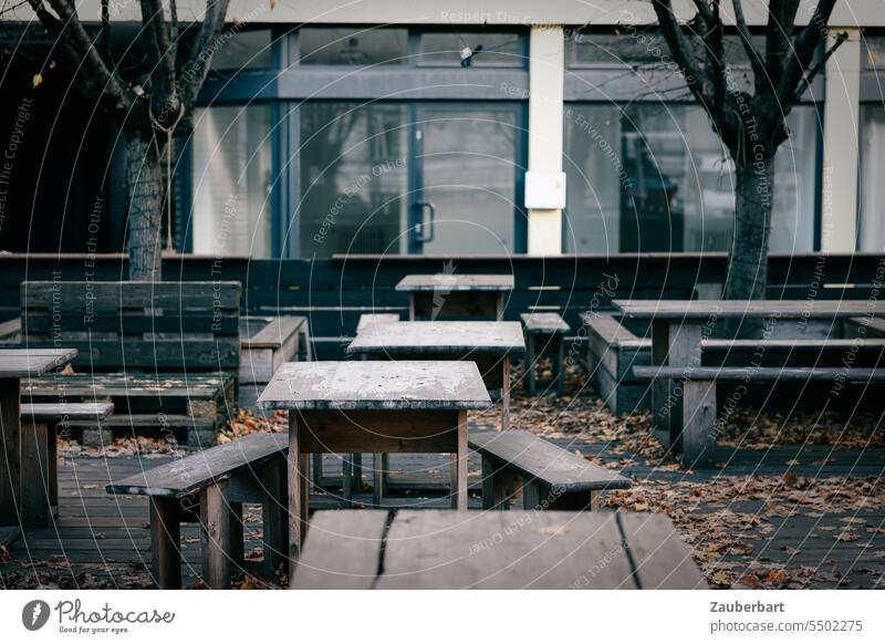 Empty tables and benches in the outdoor area of a restaurant with modern facade in autumn Café Autumn forsake sb./sth. Dark Cold Holiday season over Closed