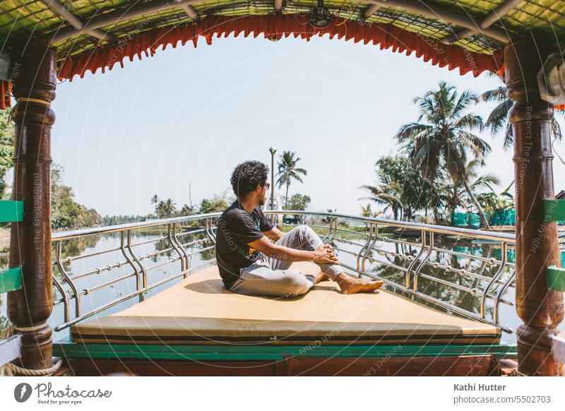 a young men sits on the front of a boat in the backwaters of Alappuzha Boating trip Watercraft Vacation & Travel Trip Ocean Colour photo Adventure Tourism