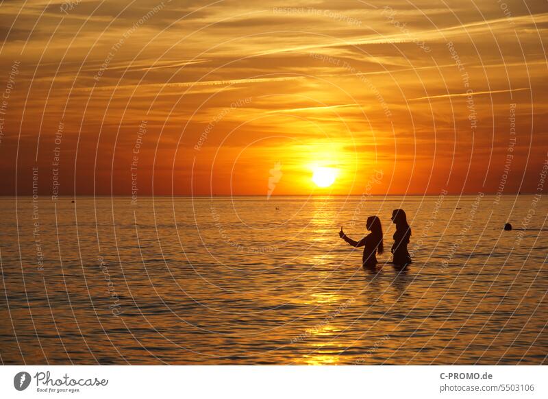 Women taking selfies before sunset Sunset Selfie Cellphone girlfriends Ocean Baltic Sea Evening Horizon Friends Vacation photo social media