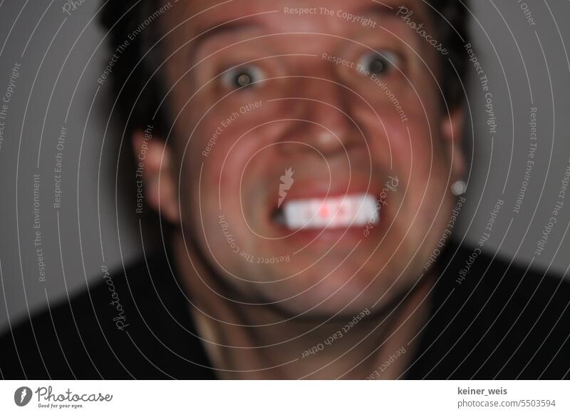 A man shows creepy glowing white and red teeth in blurred photograph with teeth lighting Creepy Teeth Dental lighting Man Face illustration horrendous