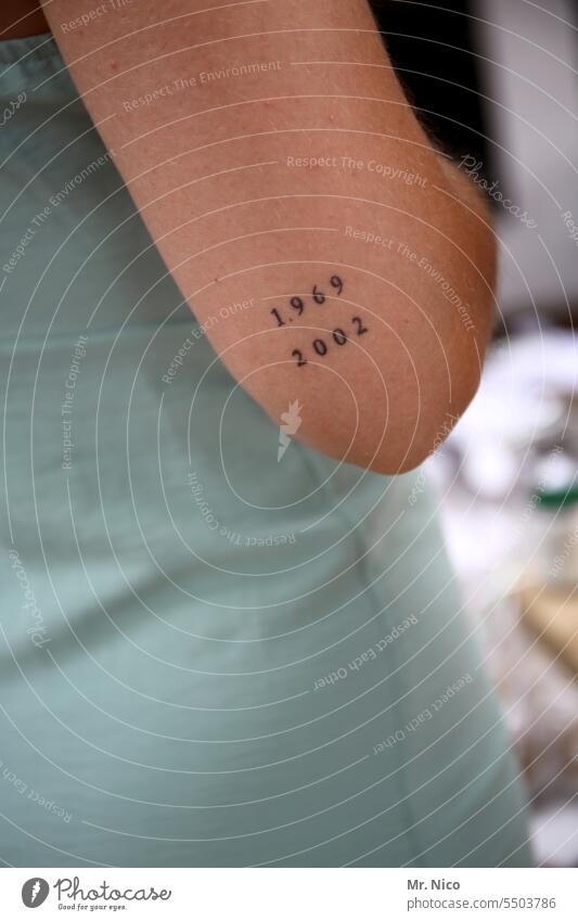1969 / 2002 Arm Tattoo Upper arm Skin Year number Digits and numbers Characters Tattooed tattoos Feminine Delicate Elbow elbow body part year of birth