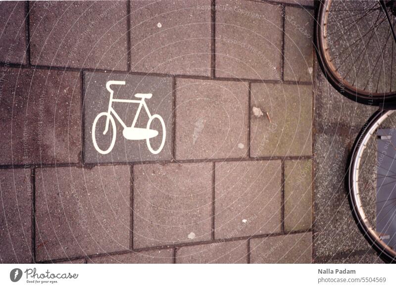 Bicycles on the road Analog Analogue photo Colour Colour photo Cycle path Sign Tire Wheel rim Coat Exterior shot Spokes Detail Bicycle tyre Mobility mark