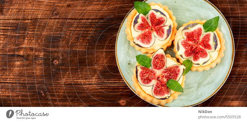 Delicious mini tartlet with figs. sweet food dessert pastry fruit cake pie homemade cream copy space space for text baked fresh bakery wooden table
