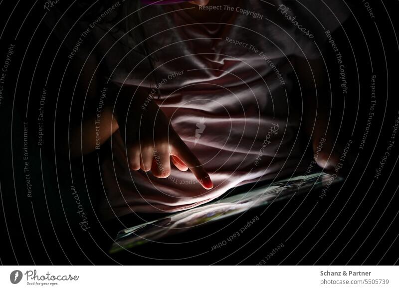 Child plays in the dark on a tablet and is only illuminated by the screen Chat media pedagogy Media social media SMS Telephone Internet Cellphone whatsapp