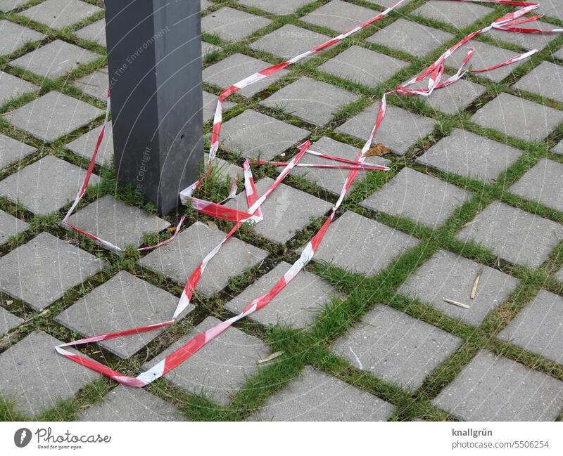 barrier tape flutterband Reddish white Safety Protection cordon prevention Deserted Ground Pattern squares Checkered Pole Grass Gray Green Exterior shot