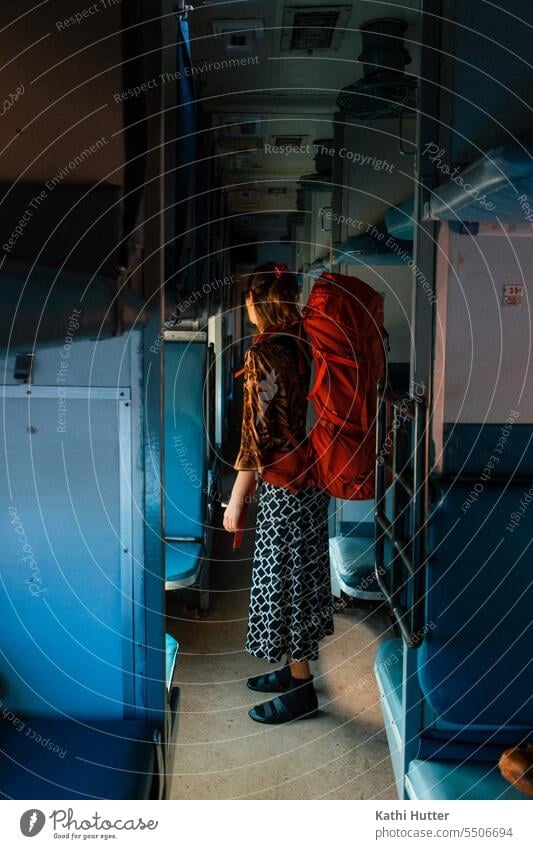 a woman is standing in an indian sleeping train. On her back she carries a red travel backpack. Train Railroad Transport Vacation & Travel Train travel