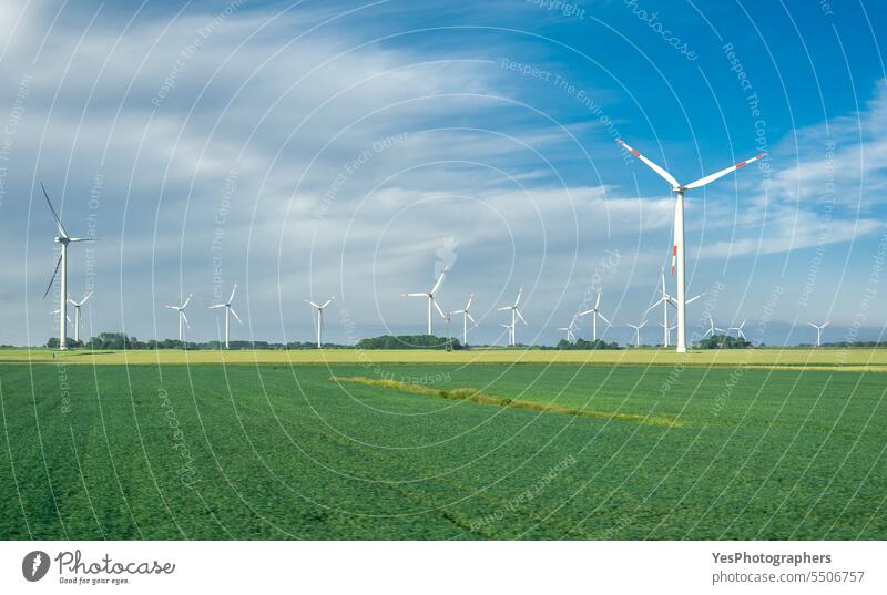 Windmill farm on an agricultural field on the North Sea coastline, Germany agriculture alternative blade blue bright clean clouds color countryside development