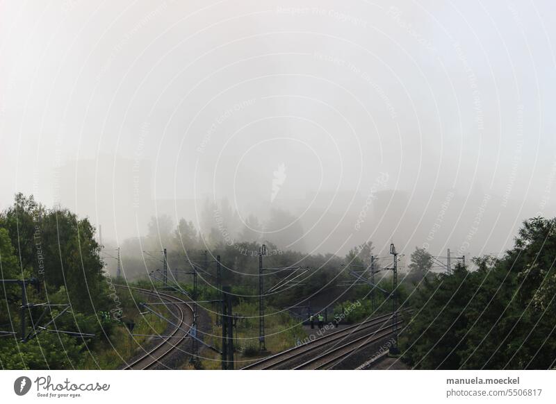 Dusty air at the railroad tracks after chimney blasting Fog Dreary Air Track Pole trees Shadow silhouettes triangular track Track bed Working man Human being