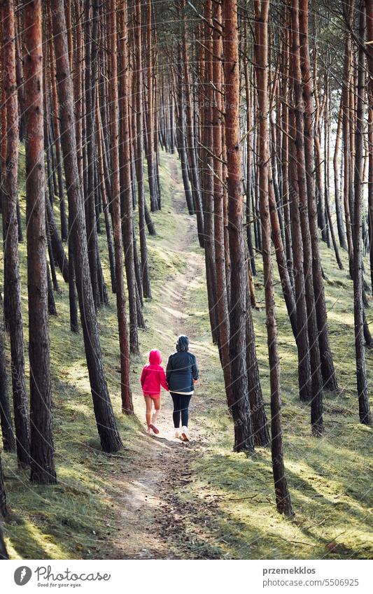 Summer vacation trip close to nature. Family walking in forest. People actively spending leisure time. Woman with daughter enjoying long walk during summertime