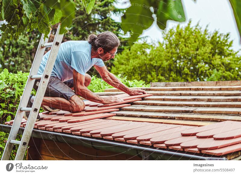 Roof renovation garden house. Roofer at work, covering roof with clay tile Gardenhouse clay tiles Flake Summer house outbuilding Wood New brick active
