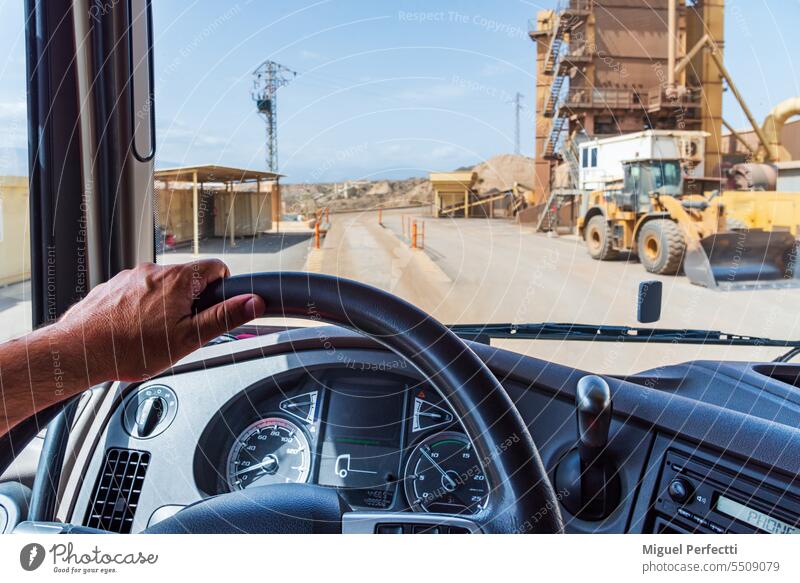 View from the driver's position of a truck entering an aggregate plant with scales and industrial machinery. Truck inward view Weighbridge Steering wheel