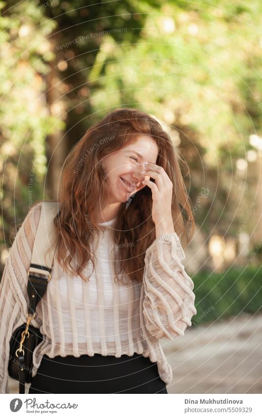 candid portrait of young beautiful woman laughing backlit with sunlight in summer. Pretty ginger girl with red hair. lauhging park smiling happy pretty Smiling