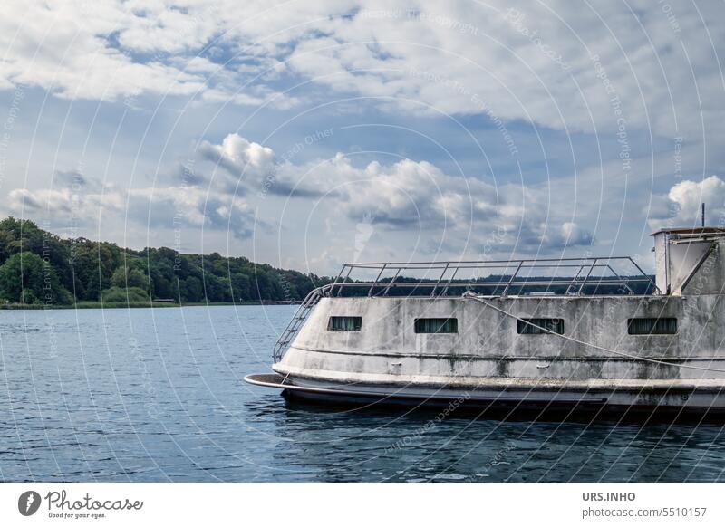 An aging white houseboat on a large lake under blue sky with clouds Houseboat Water Exterior shot Deserted Navigation Vacation & Travel Boating trip Day