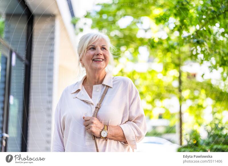 Portrait of happy senior woman standing in the city people caucasian healthy city life gray hair enjoy street casual day portrait outside real people