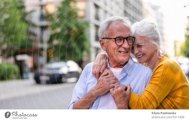 Portrait of happy elderly couple embracing in the city people Caucasian Stand Healthy City life grey hair To enjoy Street Easygoing Day portrait outside