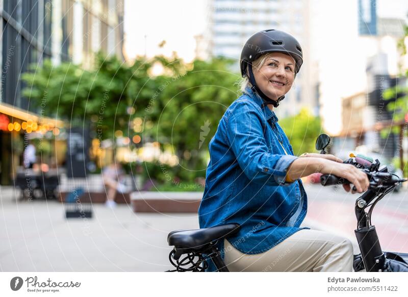 Portrait of senior woman wearing helmet while riding bicycle in the city people caucasian standing healthy city life gray hair enjoy street casual day portrait