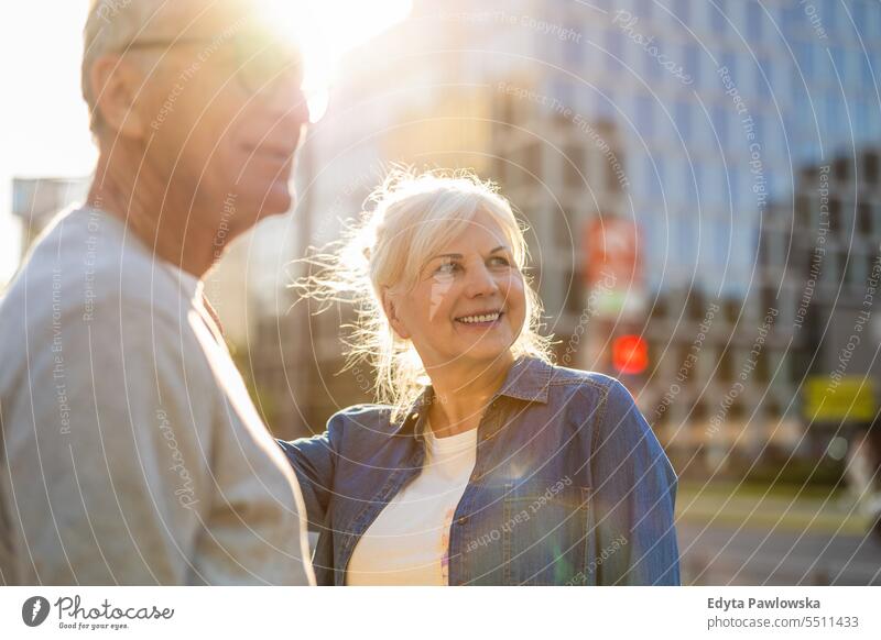 Portrait of happy senior couple standing in city street on a sunny day people caucasian healthy city life gray hair enjoy casual portrait outside real people